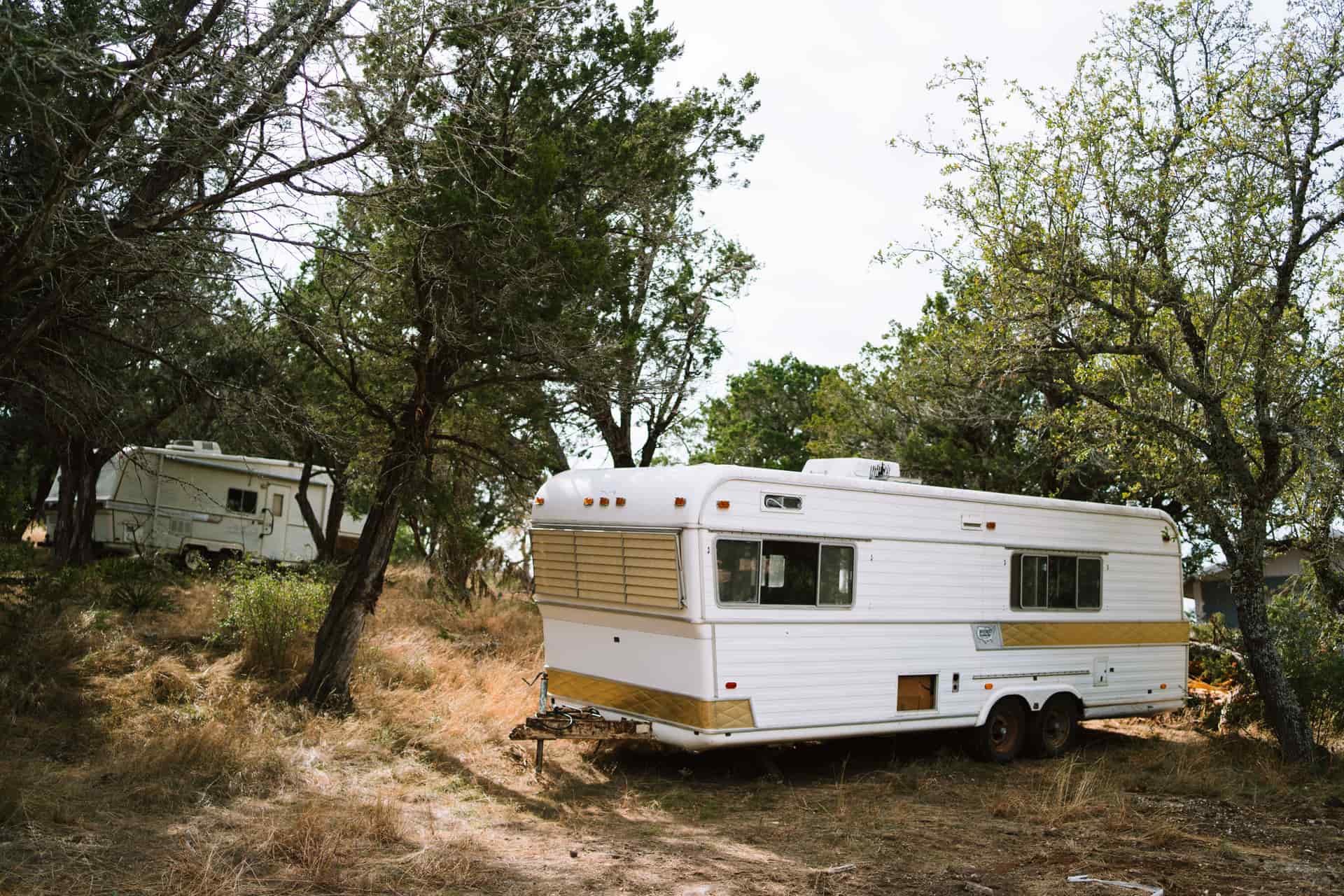 A camper trailer wheel resting on a gravel campsite pad