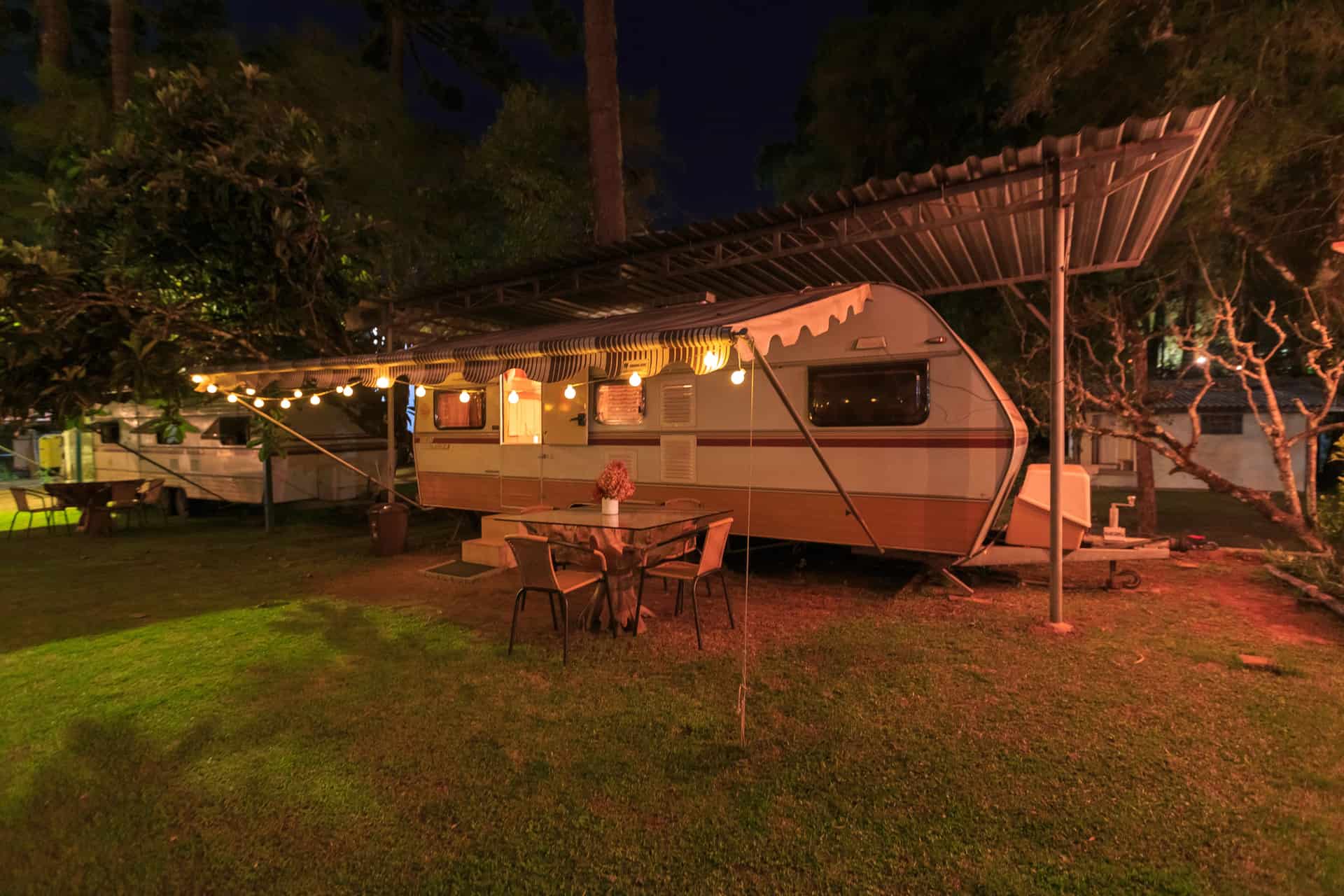 A travel trailer set up at a campsite in the evening