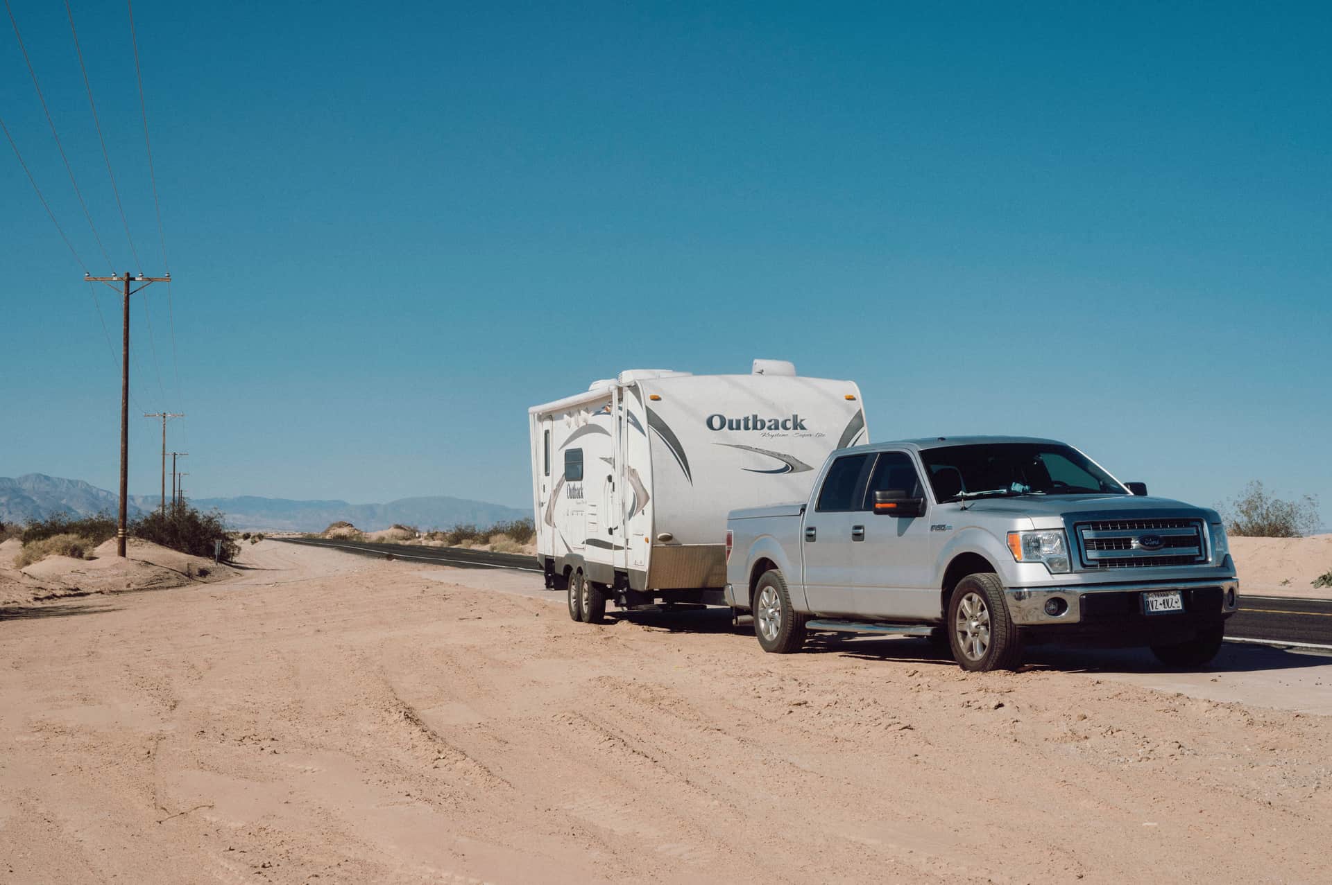 A pickup truck towing a travel trailer on the road